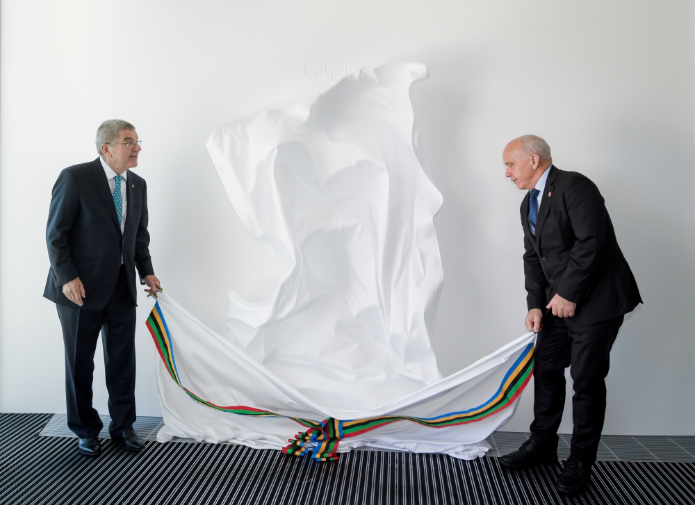 International Olympic Committee (IOC) President Thomas Bach (C) raises the key next to senior architect Jan Ammundsen (L) during the inauguration of the new IOC headquarters in Lausanne, Switzlerland, Sunday ahead of the decision on 2026 Winter Games host. — Reuters