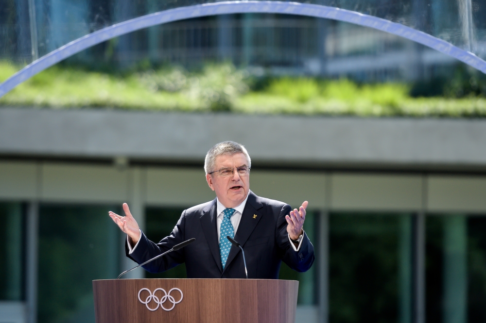 International Olympic Committee (IOC) President Thomas Bach (C) raises the key next to senior architect Jan Ammundsen (L) during the inauguration of the new IOC headquarters in Lausanne, Switzlerland, Sunday ahead of the decision on 2026 Winter Games host. — Reuters