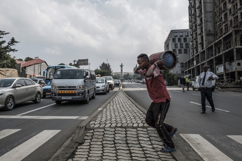 A man carries a gas cylinder as he makes his way across the central street in the capital Addis Ababa on Monday. — AFP