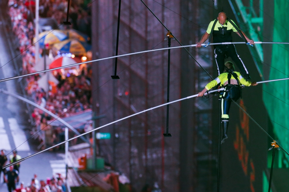 Aerialist Nik Wallenda walks the highwire with his sister Lijana as they greet the crowd over Times Square in New York. — Reuters