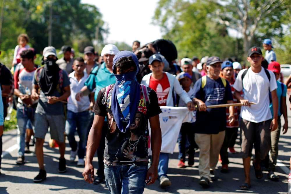 People belonging to a caravan of migrants from Honduras en route to the United States, walk on a highway in Metapa, Mexico, April 12. -Reuters 