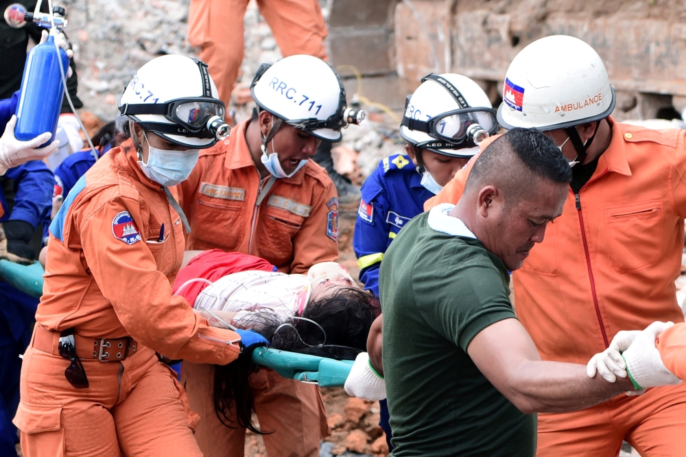 A rescue team carries a wounded worker at a collapsed building in Sihanoukville, Cambodia, Saturday. -Reuters
