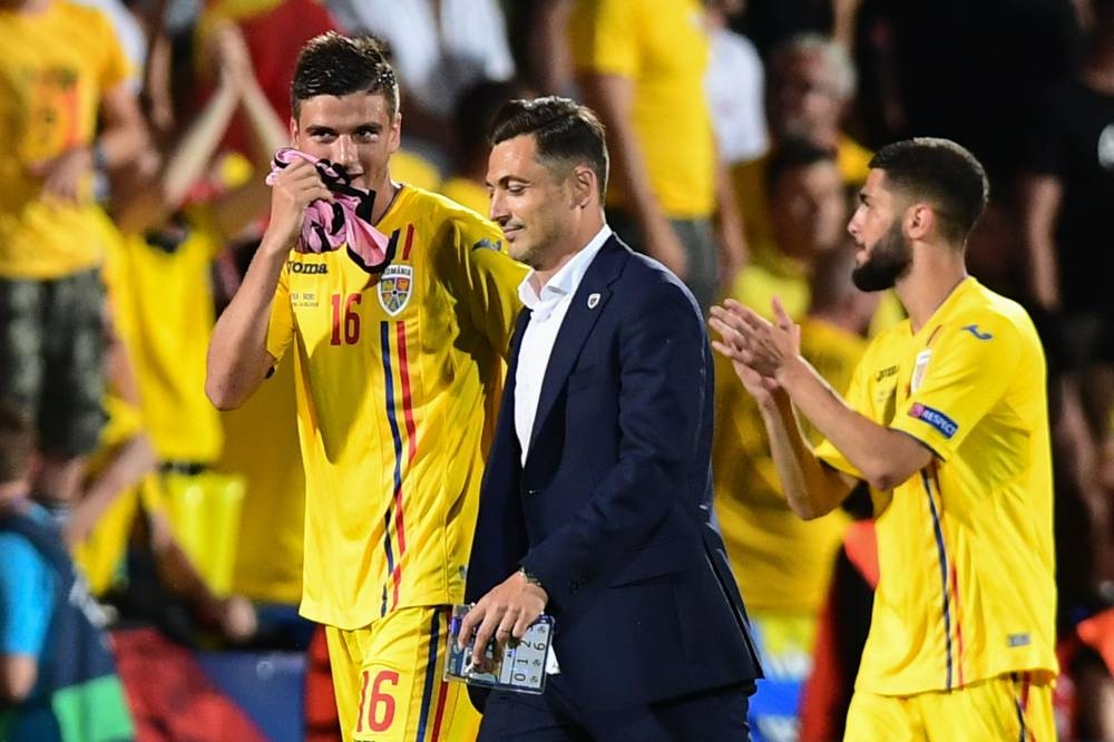 Romania's head coach Matei Mirel Radoi (C) talks with Romania's midfielder Dragos Nedelcu (L) at the end of the Group C match of the U21 European Football Championships against France at the Dino-Manuzzi stadium in Cesena on Monday. — AFP