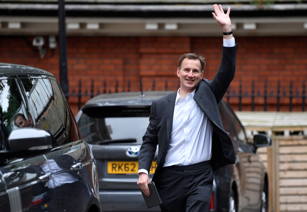 Conservative Party leadership candidate Jeremy Hunt waves as he leaves his home in London on Wednesday. — Reuters