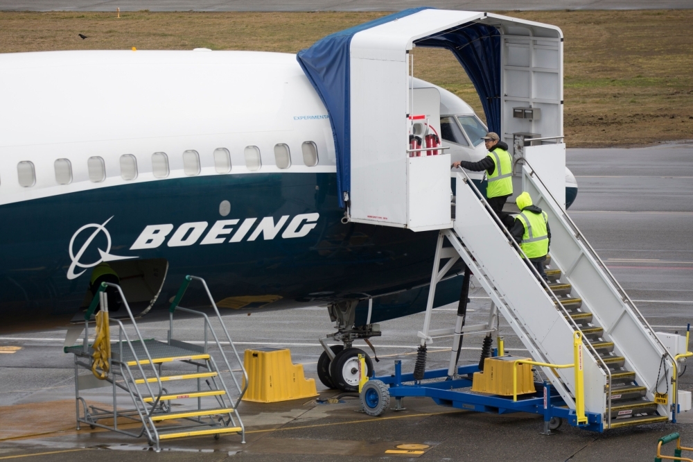Workers are pictured next to a Boeing 737 MAX 9 airplane on the tarmac at the Boeing Renton Factory in Renton, Washington, in this March 12, 2019 file photo. — AFP