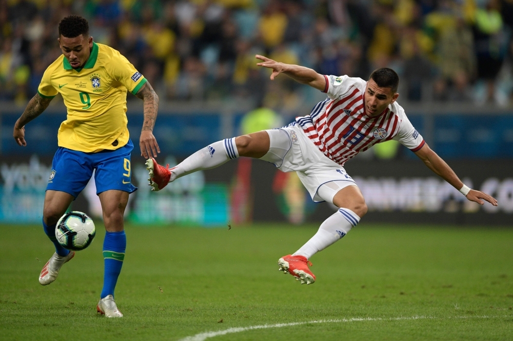 Brazil's Gabriel Jesus (L) is marked by Paraguay's Junior Alonso during their Copa America football tournament quarterfinal match at the Gremio Arena in Porto Alegre, Brazil, on Thursday. — AFP