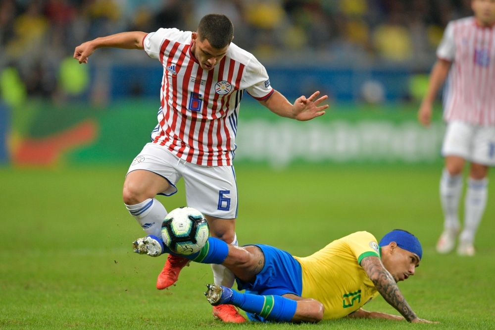 Brazil's Gabriel Jesus (L) is marked by Paraguay's Junior Alonso during their Copa America football tournament quarterfinal match at the Gremio Arena in Porto Alegre, Brazil, on Thursday. — AFP