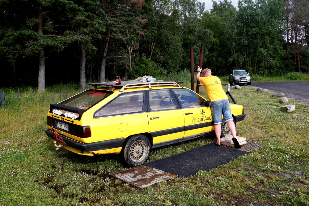 Willem Maesalu, inventor and owner of the old yellow Audi car converted into a small sauna, drives in the parking lot in Tallinn, Estonia, on Thursday. — Reuters