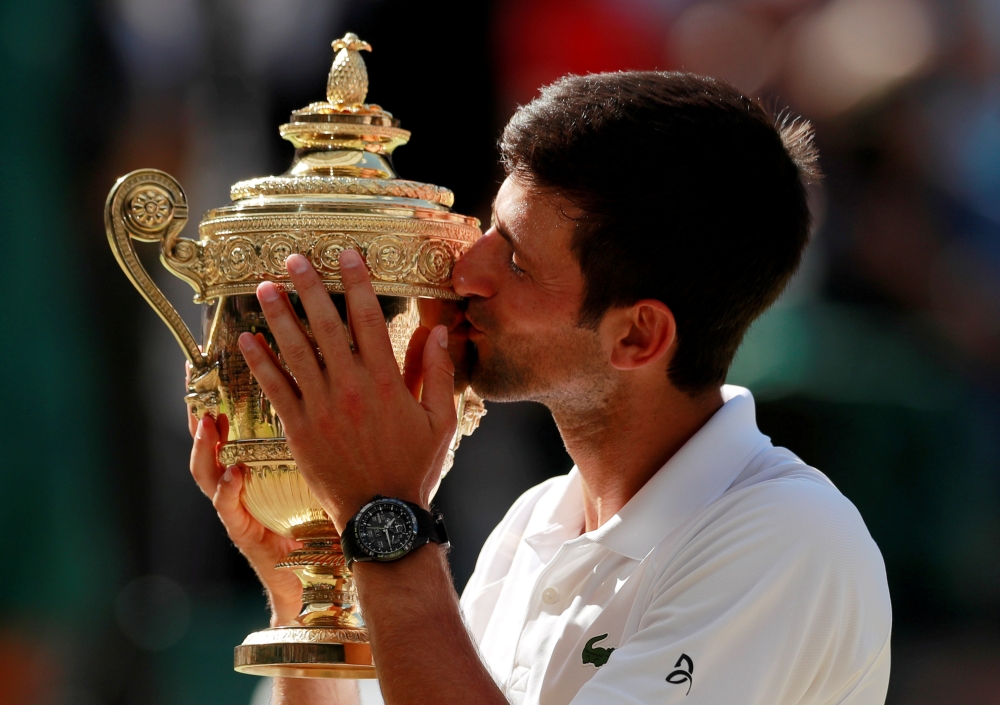Serbia's Novak Djokovic celebrates with the trophy after winning the men's singles Wimbledon final against South Africa's Kevin Anderson at All England Lawn Tennis and Croquet Club, London, Britain in this July 15, 2018, file photo. — Reuters
