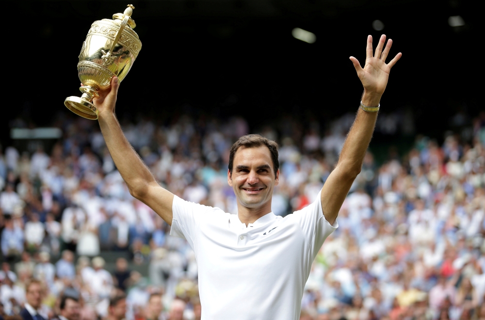 Serbia's Novak Djokovic celebrates with the trophy after winning the men's singles Wimbledon final against South Africa's Kevin Anderson at All England Lawn Tennis and Croquet Club, London, Britain in this July 15, 2018, file photo. — Reuters