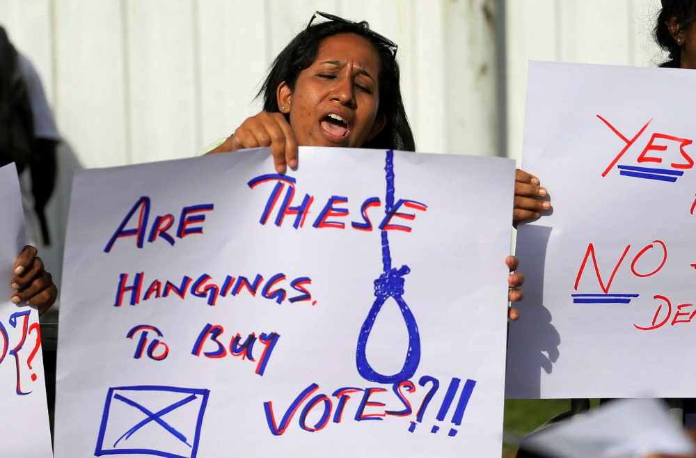 A Sri Lankan woman holds a placard during a protest condemning signed death sentences for four people convicted of drug-related offenses in a decision by Sri Lanka's President Maithripala Sirisena, in front of the Welikada Prison in Colombo, Sri Lanka, on Friday. — Reuters