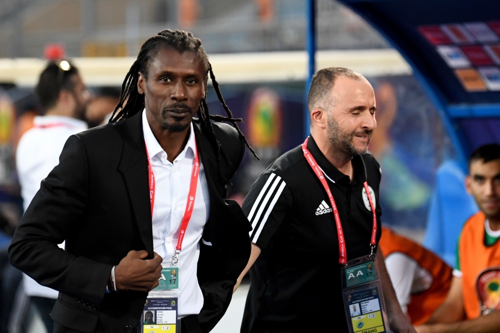 Senegal's coach Aliou Cisse (L) and Algeria's coach Djamel Belmadi walk together ahead of the 2019 Africa Cup of Nations (CAN) football match between Kenya and Tanzania at the June 30 Stadium in Cairo on Thursday.  — AFP