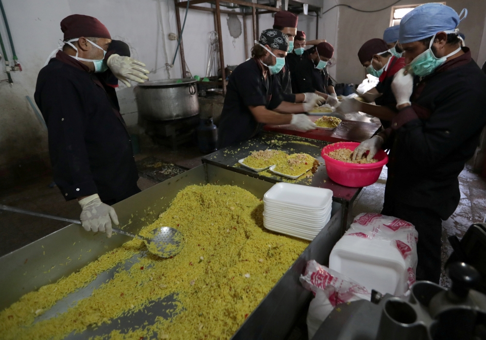 Volunteers prepare meals to be delivered to fighters, in the town of Atarib, Syria.