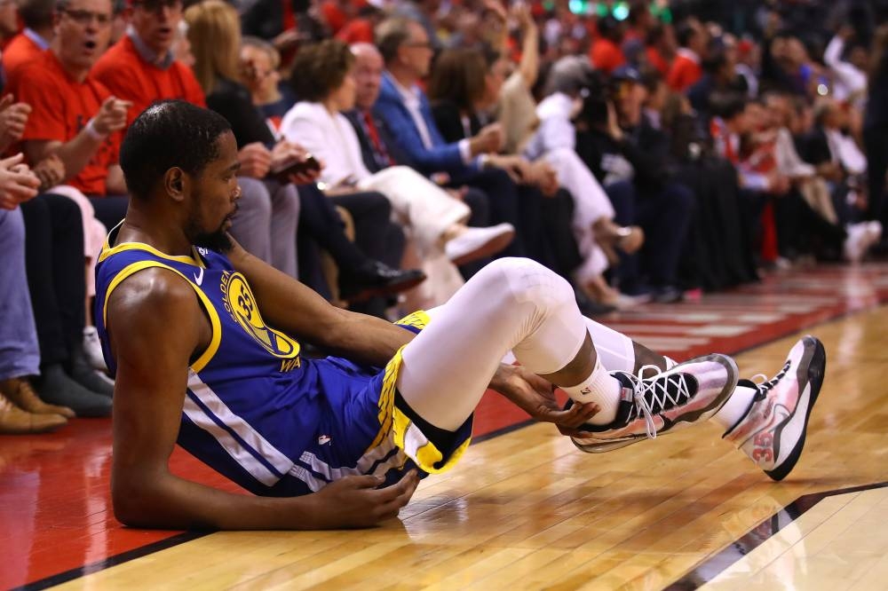 In this file photo taken on June 10, 2019  Kevin Durant No. 35 of the Golden State Warriors reacts after sustaining an injury during the second quarter against the Toronto Raptors during Game Five of the 2019 NBA Finals at Scotiabank Arena in Toronto, Canada. Warriors star forward Durant has declined a $31.5 million option for next season and will become an unrestricted NBA free agent. Also Durant and Kawhi Leonard have discussed signing free-agent deals with the same team, according to a report Saturday from ESPN. — AFP