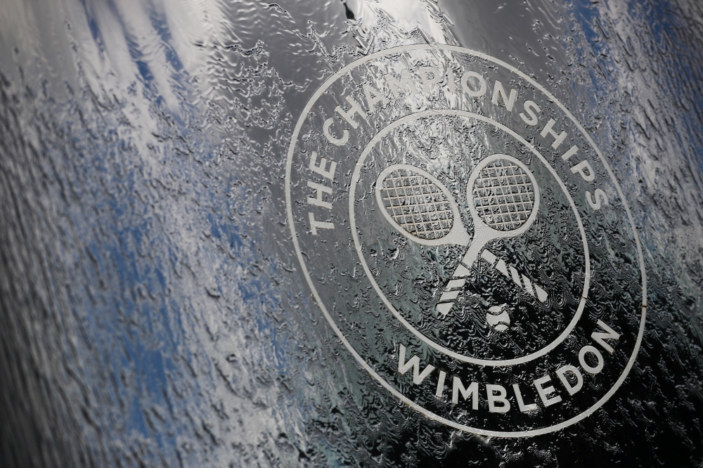 A worker puts touches up the finish on a recycling bin at The All England Tennis Club in Wimbledon, southwest London, on Sunday, on the eve of the start of the 2019 Wimbledon Championships tennis tournament. — AFP