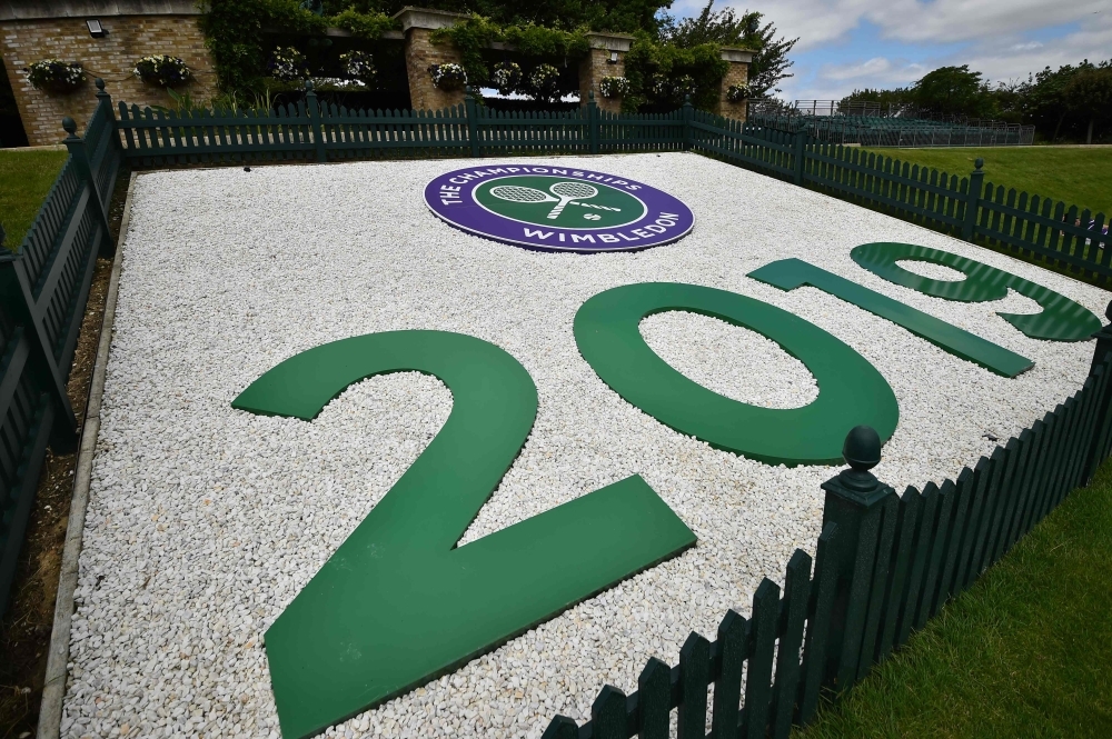 A worker puts touches up the finish on a recycling bin at The All England Tennis Club in Wimbledon, southwest London, on Sunday, on the eve of the start of the 2019 Wimbledon Championships tennis tournament. — AFP
