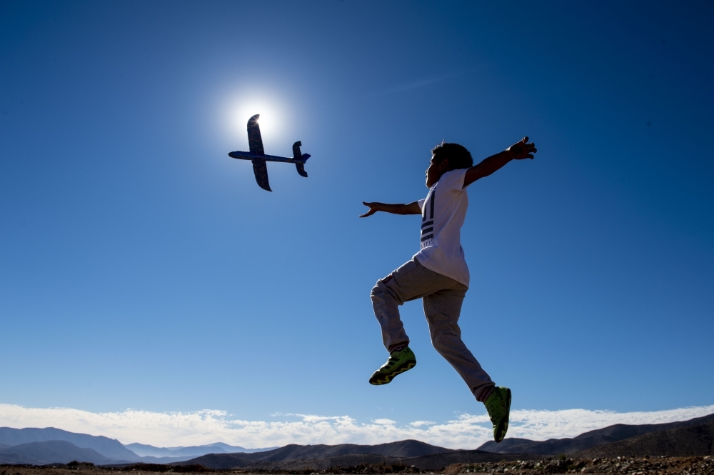 A boy plays with a toy plane on the eve of a solar eclipse, in La Higuera, Coquimbo Region, in the Atacama desert about 580 km north of Santiago, Chile, on Monday. — AFP