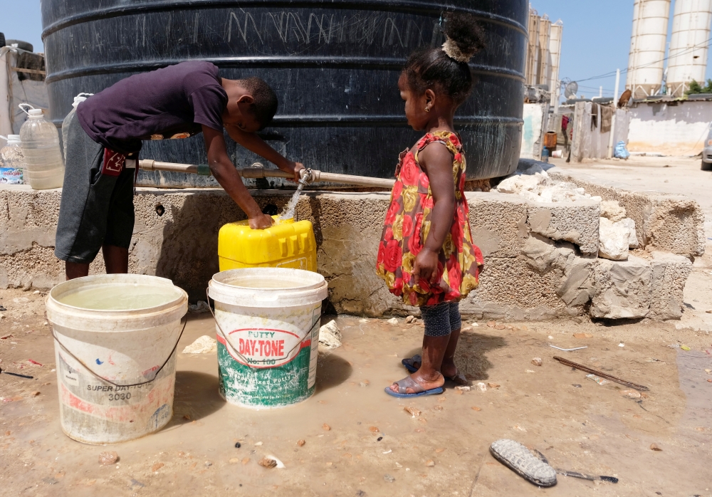 A Libyan woman displaced from the town of Tawergha fills containers with water at a displaced camp in Benghazi, Libya, in this June 19, 2019 file photo. — Reuters
