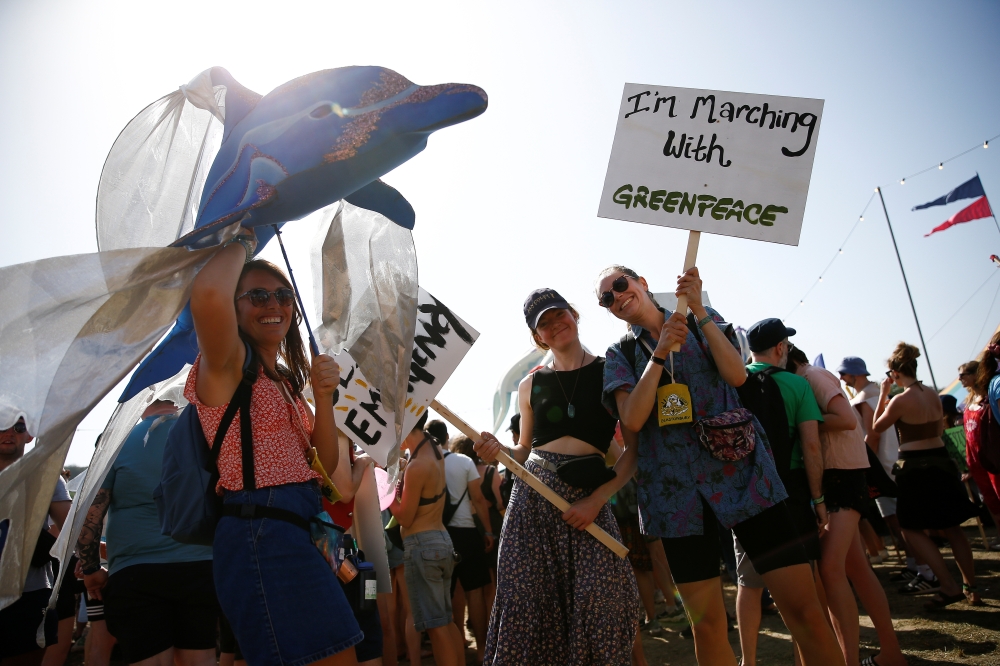 Protestors affiliated with Greenpeace take part in a procession during Glastonbury Festival at Worthy farm in Somerset, Britain on June 27. , 2019. -Reuters