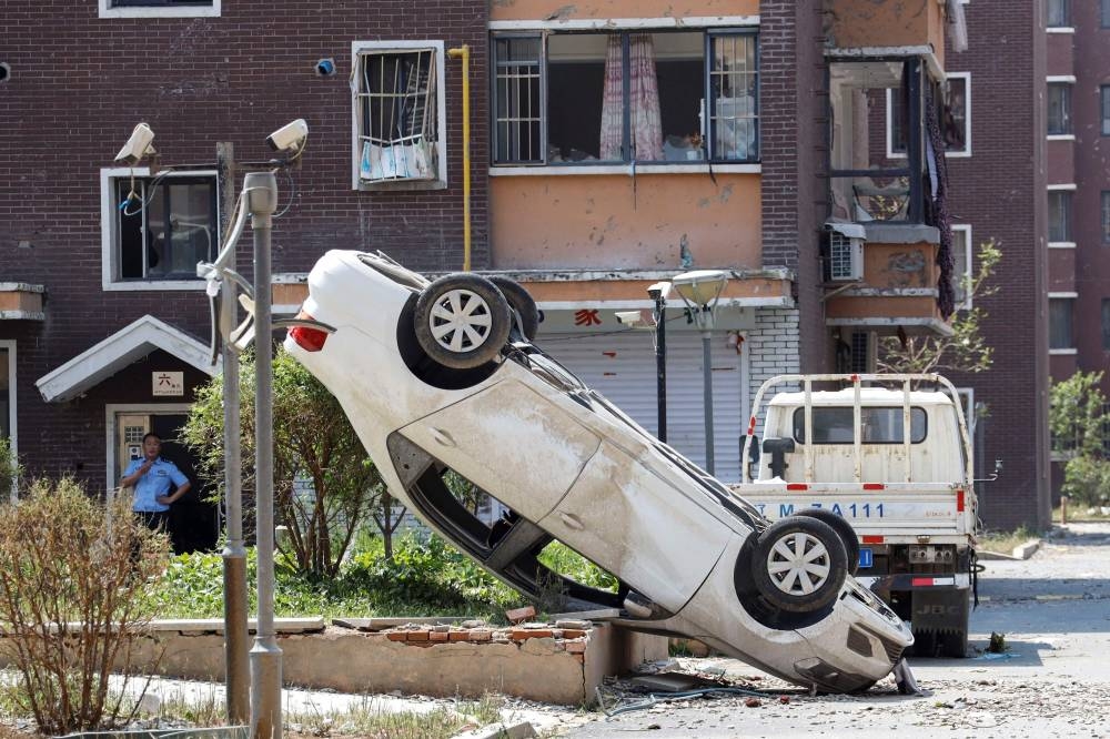 A damaged car is seen a day after a tornado hit the area in Kaiyuan in China's northeastern Liaoning province on Thursday. — AFP