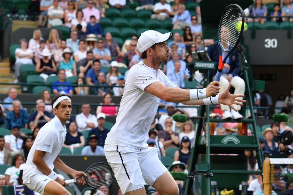 Britain's Andy Murray (R) and France's Pierre-Hugues Herbert return against Romania's Marius Copil and France's Ugo Humbert during their men's doubles first round match on the fourth day of the 2019 Wimbledon Championships at The All England Lawn Tennis Club in Wimbledon, southwest London, on Thursday. — AFP