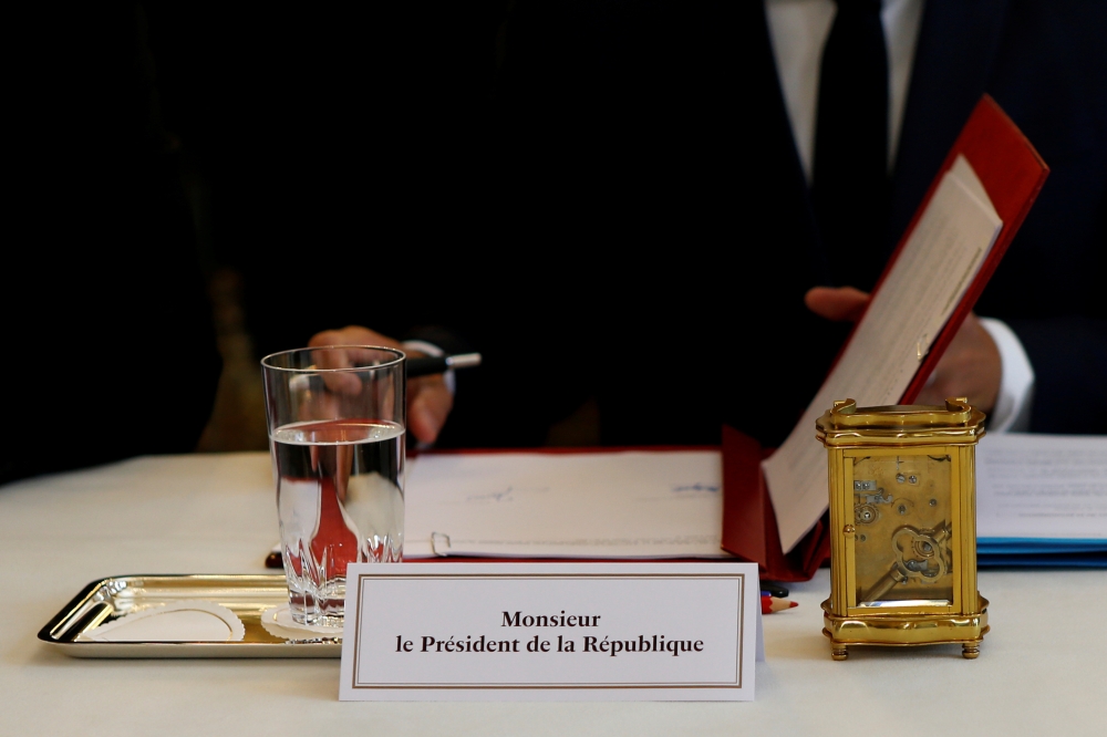 The place card for French President Emmanuel Macron and the table clock are seen during a meeting at the Elysee Palace in Paris, France, on Friday. — Reuters