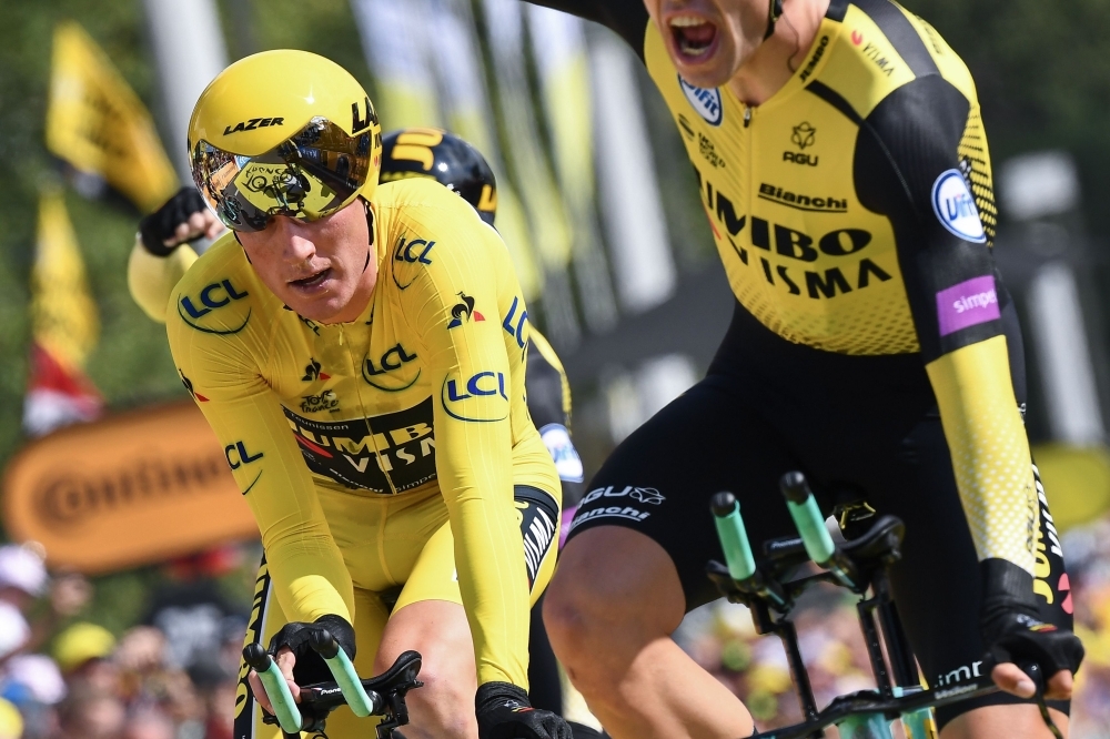 Dutch rider Mike Teunissen (L) wearing his overall leader's yellow jersey and a teammate of Netherlands' Jumbo-Visma cycling team react as they win on the finish line of the second stage of the 106th edition of the Tour de France cycling race, a 27.6km team time-trial in Brussels, Belgium, on Sunday. — AFP