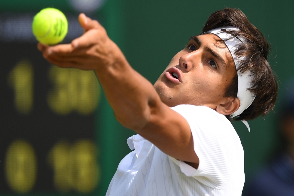 Argentina's Roman Andres Burruchaga serves to Spain's Pablo Llamas Ruiz during their boy's singles first round match on the seventh day of the 2019 Wimbledon Championships at The All England Lawn Tennis Club in Wimbledon, southwest London, on Monday. — AFP