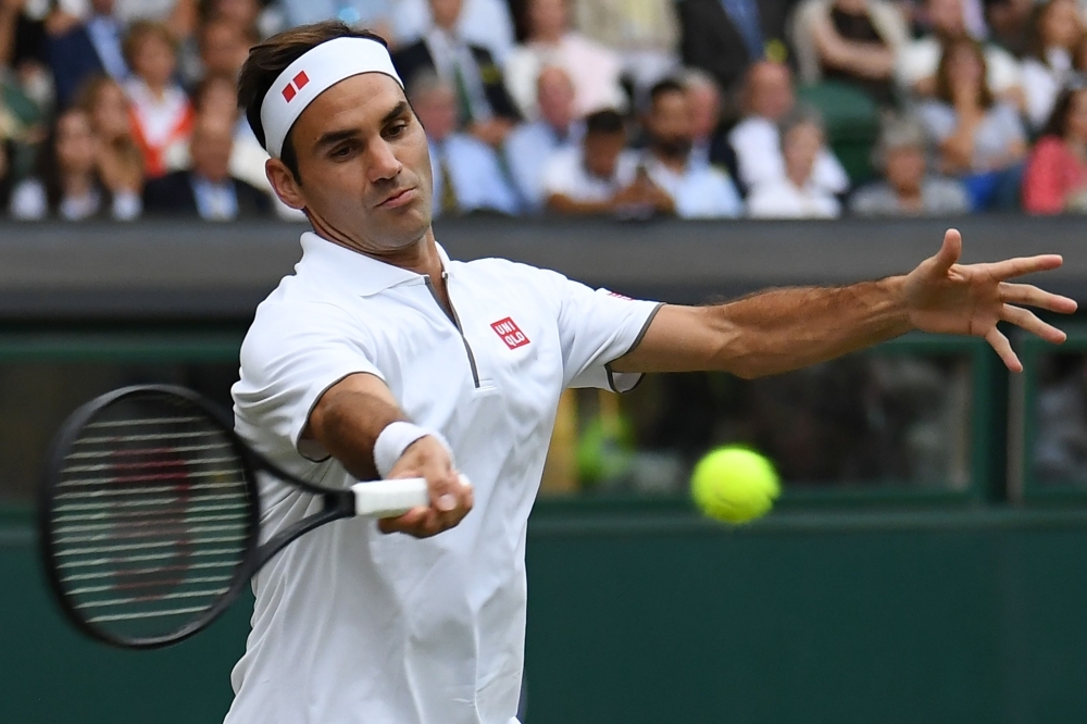 Switzerland's Roger Federer returns against Italy's Matteo Berrettini during their men's singles fourth round match on the seventh day of the 2019 Wimbledon Championships at The All England Lawn Tennis Club in Wimbledon, southwest London, on Monday. — AFP