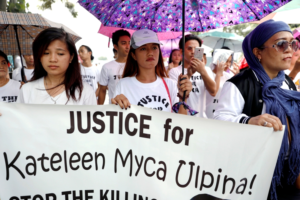 Relatives and friends of 3-year old Myca Ulpina hold banners calling for justice during her funeral in Rizal province, Philippines, on Tuesday. — Reuters