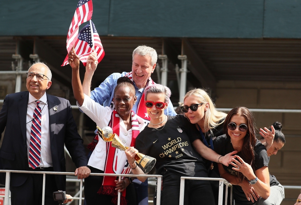 Ali Krieger, Megan Rapinoe, and Ashlyn Harris celebrate while riding on a float during the US Women's National Soccer Team Victory Parade through the Canyon of Heroes in New York City, on Wednesday. The team defeated the Netherlands 2-0 on Sunday in France to win the 2019 Womens World Cup. — AFP