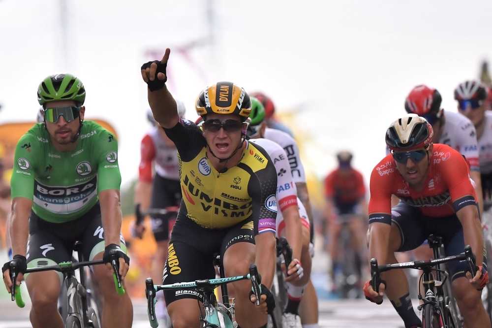 Netherlands' Dylan Groenewegen (C) celebrates, past Slovakia's Peter Sagan (L), wearing the best sprinter's green jersey, as he wins on the finish line of the seventh stage of the 106th edition of the Tour de France cycling race between Belfort and Chalon-sur-Saone, in Chalon-sur-Saone, eastern France, on Friday. — AFP