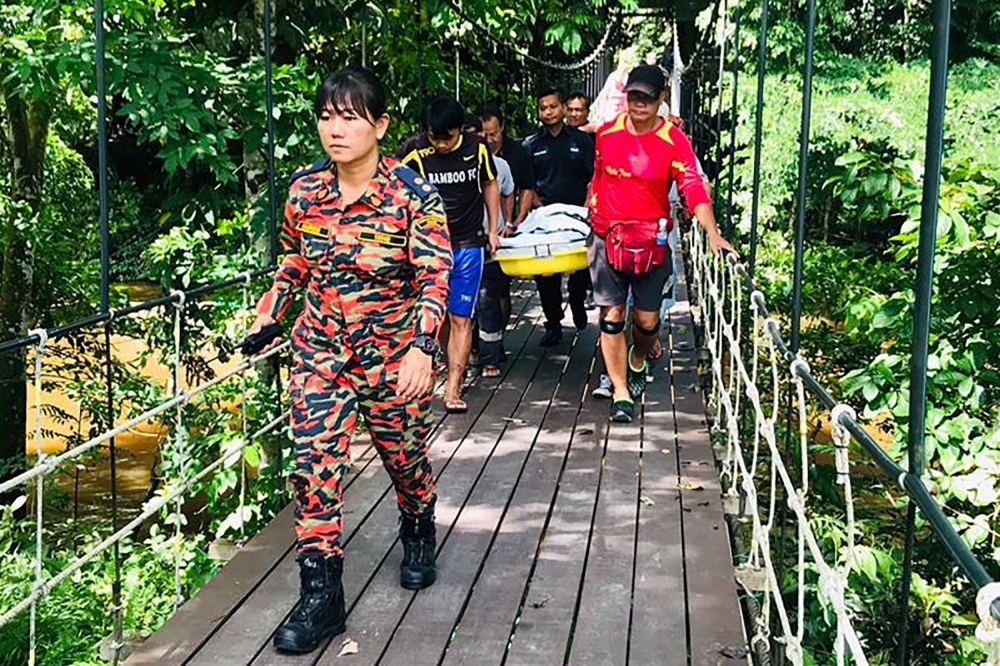 This handout from the Sarawak Fire and Rescue Department taken and released on Saturday shows the body of Dutch tourist Peter Hans Hovenkamp being carried out of Mulu National Park on the island of Borneo. -AFP