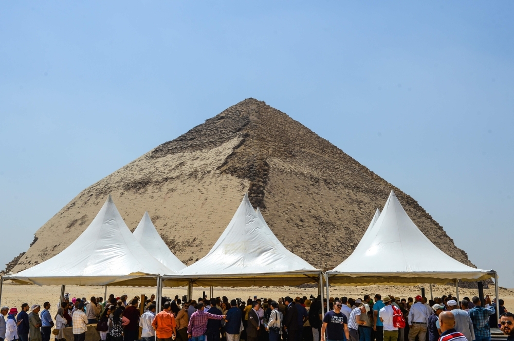 A man brushes off dust from a sarcophagus, part of a new discovery carried out almost 300 meters south of King Amenemhat II’s pyramid at Dahshur necropolis, exposed near the Bent Pyramid, about 40km (25 miles) south of the Egyptian capital Cairo, during an inaugural ceremony of the pyramid and its satellites, on Saturday. — AFP