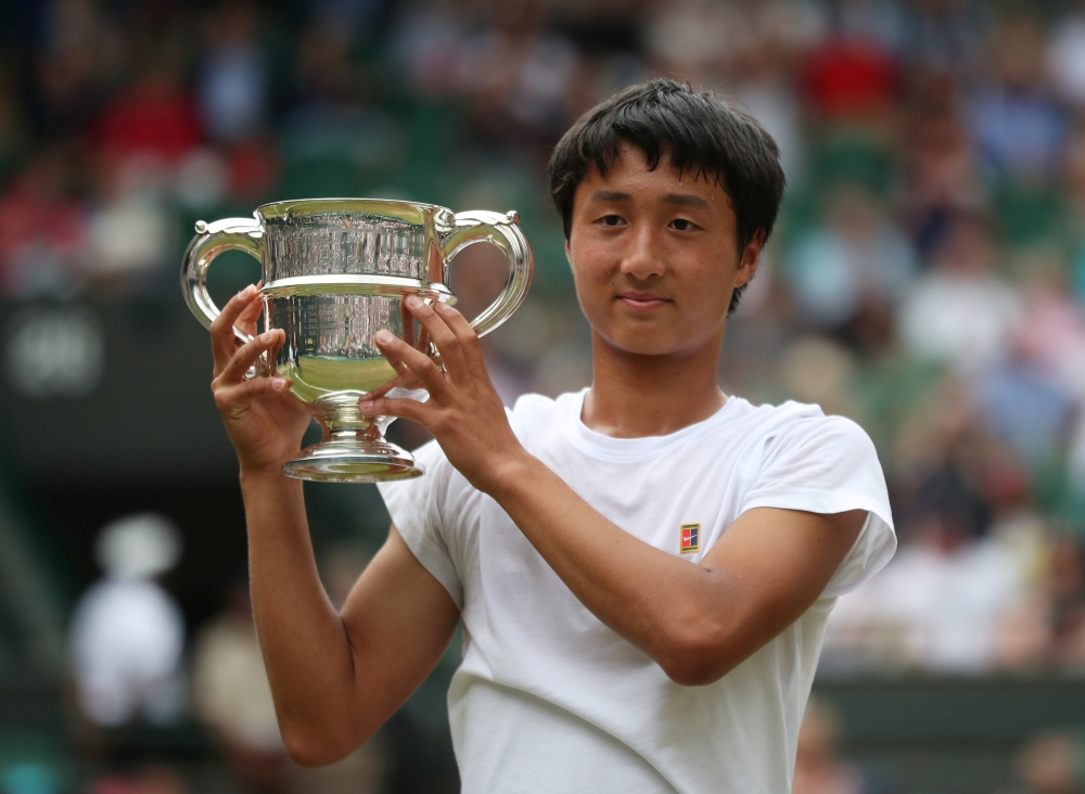 Japan's Shintaro Mochizuki poses with a trophy as he celebrates winning the Wimbledon boys' singles final against Spain's Carlos Gimeno Valero at the All England Lawn Tennis and Croquet Club, London, Britain, on Sunday. — Reuters