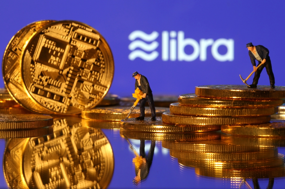 Small toy figures are seen on representations of virtual currency in front of the Libra logo in this illustration picture, taken on June 21, 2019. — Reuters