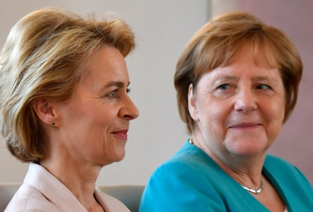 Newly elected European Commission President and outgoing German Defence Minister Ursula von der Leyen sits next to German Chancellor Angela Merkel prior to a handover ceremony led by the vice-president of the Bundesrat, upper house of parliament, unseen, at Bellevue Castle in Berlin, on Wednesday. — AFP