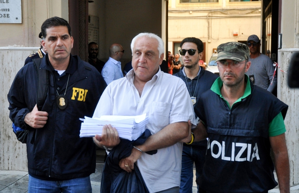 US Federal Bureau of Investigation officer, left, and Italian police officer, right, escort Tommaso Inzerillo after he was arrested in Palermo during an police/FBI operation called 'New Connection' in Palermo on Wednesday. — AFP
