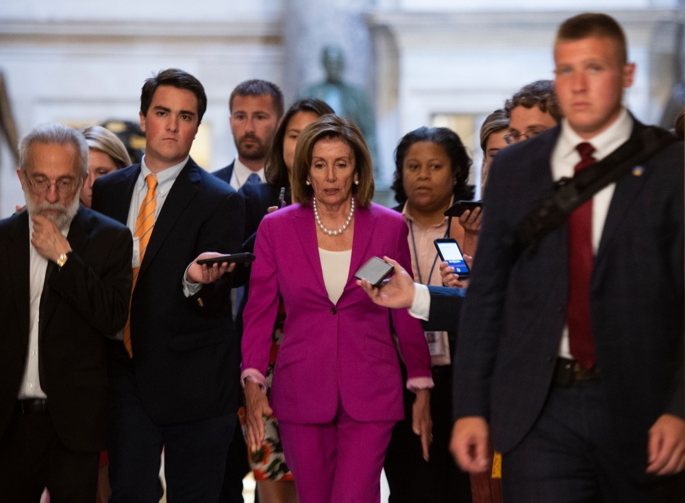 US speaker of the House, Nancy Pelosi, center, walks with reporters, before the Democrat controlled House of Representatives passed a resolution condemning US President Donald Trump for his 