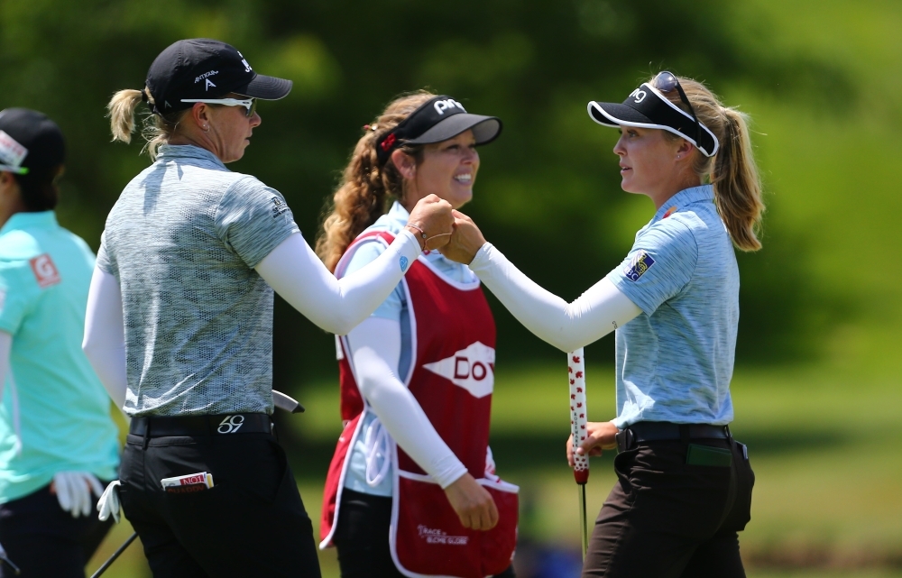 (L-R) Alena Sharp of Canada celebrates with Brooke Henderson of Canada on the ninth hole after their first round of the Dow Great Lakes Bay Invitational at Midland Country Club on Wednesdayin Midland, Michigan.  — AFP
