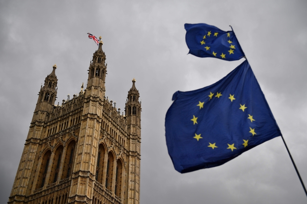 The Union flag flies atop the Houses of Parliament as EU flags held by demonstrators flutter in central London in this April 4, 2019 file photo. — AFP