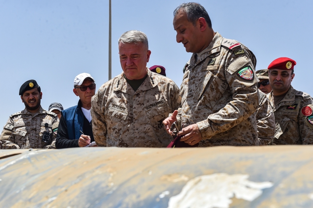 US Marine Corps General Kenneth F. McKenzie Jr. (C, behind), commander of the US Central Command (CENTCOM) and Lieutenant General Fahd bin Turki bin Abdulaziz al-Saud (front), commander of the Saudi-led coalition forces in Yemen, are shown reportedly Iranian weapons seized by Saudi forces from Yemen's Huthi rebels, during his visit to a military base in al-Kharj in central Saudi Arabia on July 18, 2019.  / AFP / Fayez Nureldine
