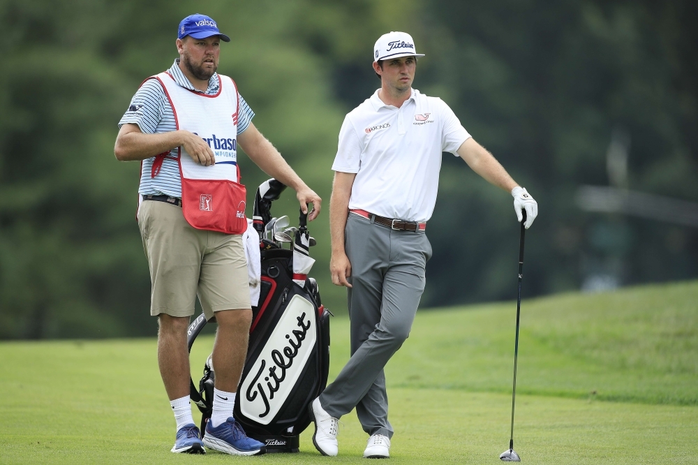 J.T. Poston of the United States talks with his caddie before playing a shot on the 11th hole during the first round of the Barbasol Championship on Thursday in Nicholasville, Kentucky. — AFP