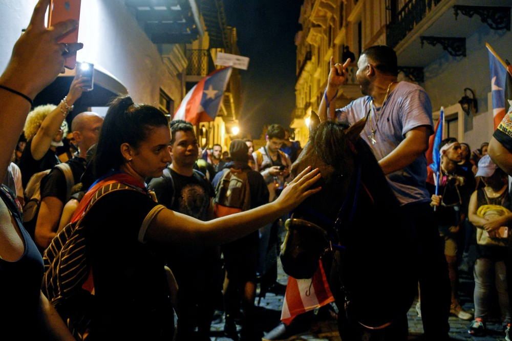 Demonstrators join the march on horses, what is called on the island a 