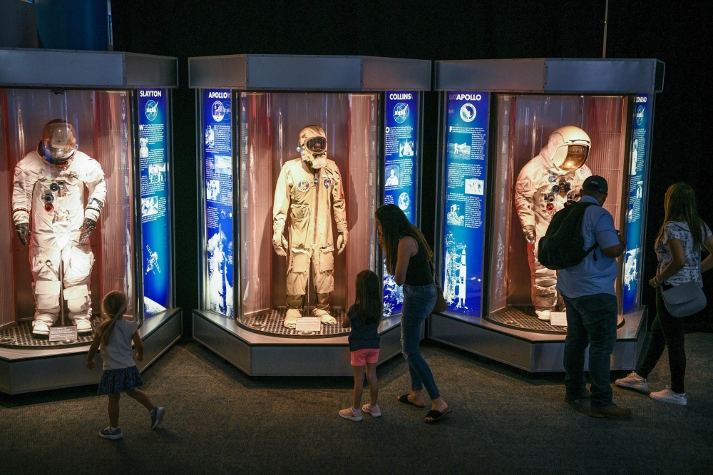 Attendees look at space suits during the Apollo 11, 50th Live celebration at Space Center Houston on Friday, in Houston, Texas. — AFP