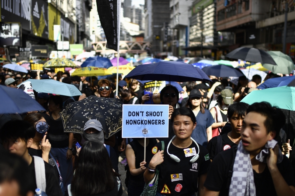 Protesters march against a controversial extradition bill in Hong Kong on Sunday. -AFP photo