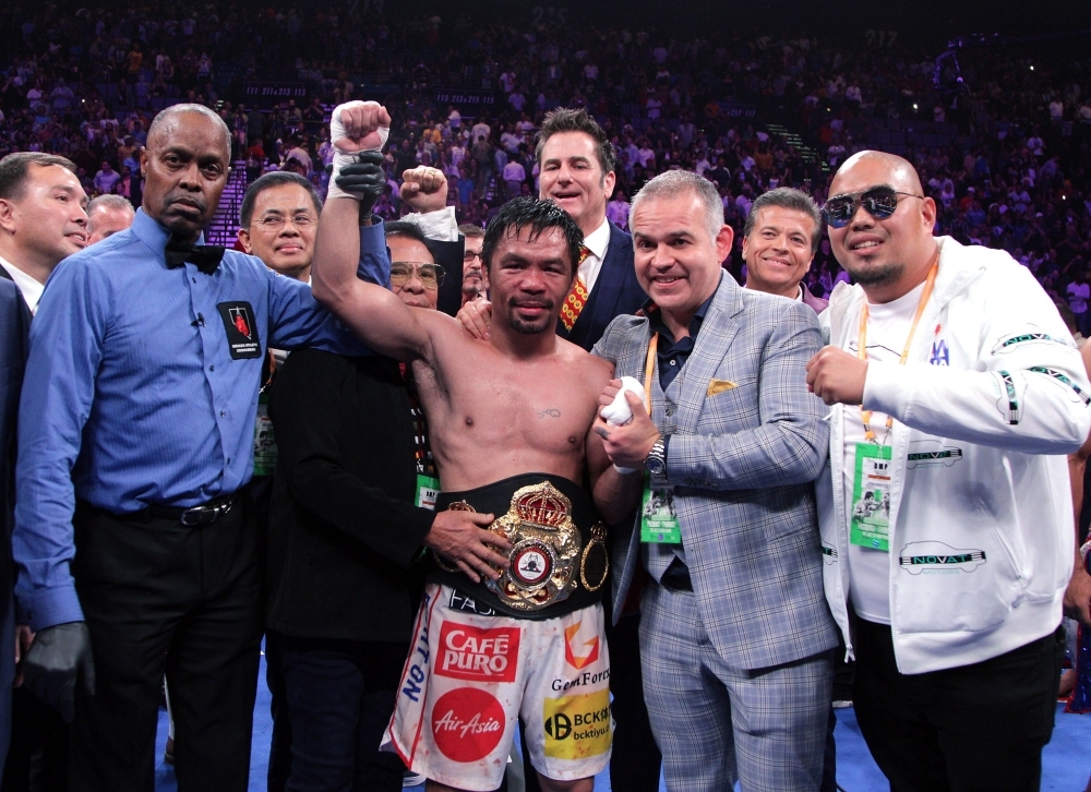 Filipino boxer Manny Pacquiao (C) celebrates after defeating US boxer Keith Thurman during their WBA super world welterweight title fight at the MGM Grand Garden Arena in Las Vegas, Nevada, on Saturday. Pacquiao won a 12 round split decision. – AFP