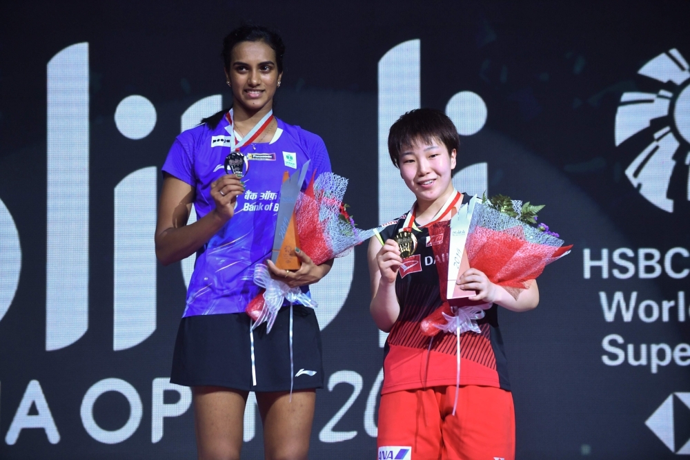 Winner Chou Tien-chen (R) of Taiwan and runner up Anders Antonsen (L) of Denmark pose for photographers following their men's singles final match at the Indonesian Open Badminton tournament in Jakarta, on Sunday. —  AFP
