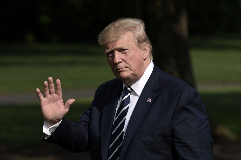 US President Donald Trump waves as he returns to the White House in Washington, DC, on Sunday. -AFP photo