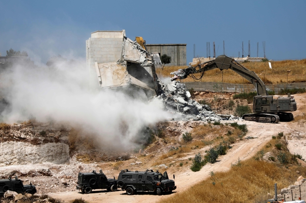 Israeli security forces tear down a Palestinian building still under construction on Monday in the West Bank village of Dar Salah, adjacent to the Sur Baher area which straddles the West Bank and Jerusalem. -AFP photo